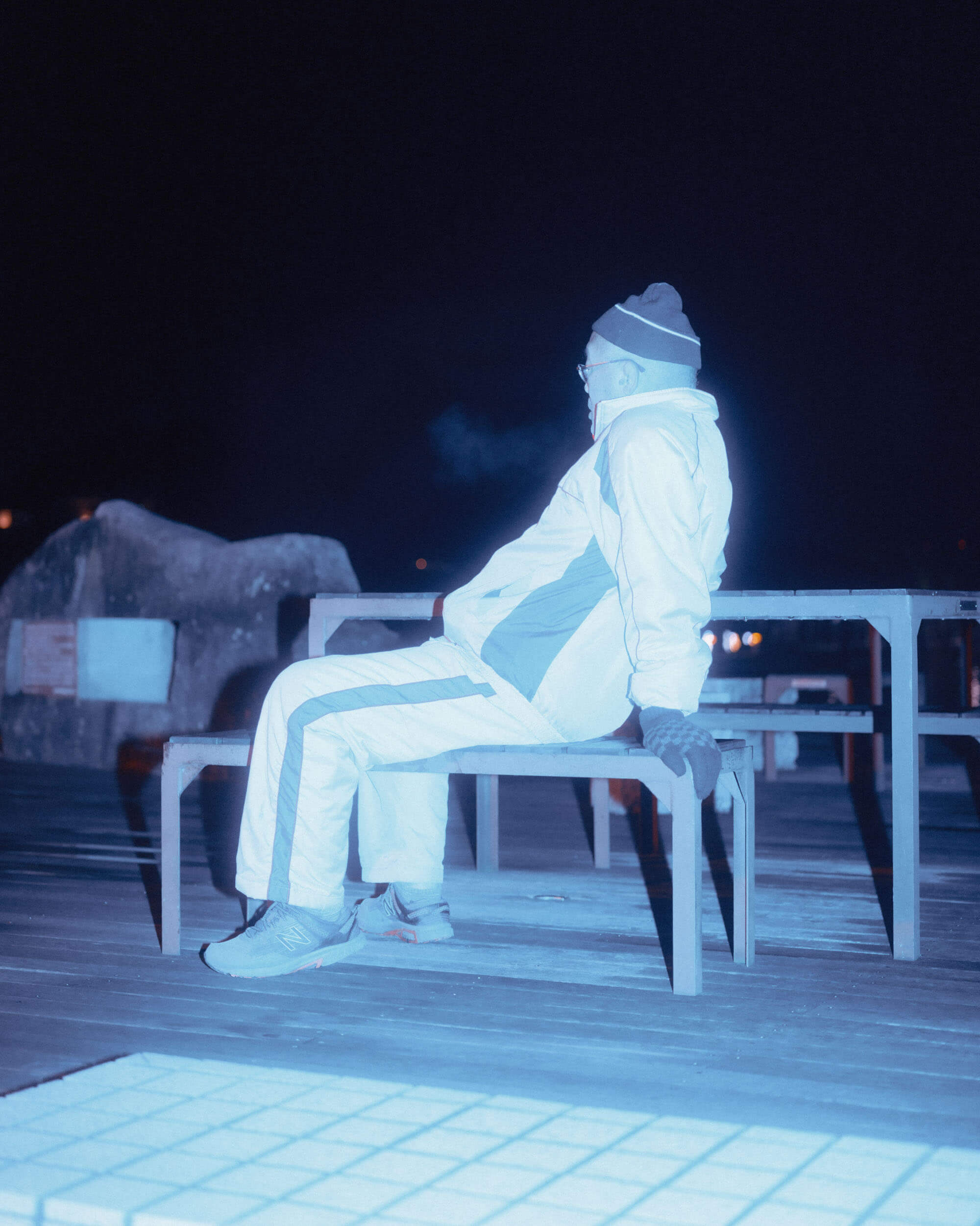 Man resting on a bench by the dock in Onomichi, Japan