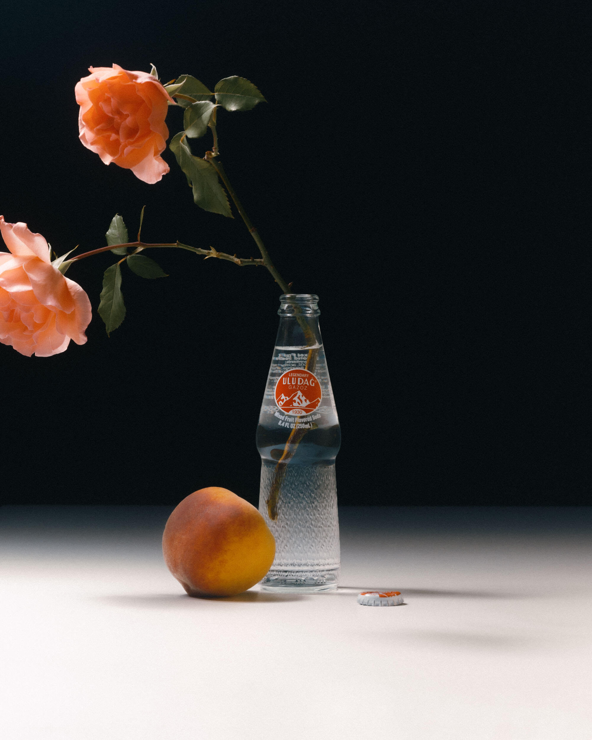 Still life of Uludag, roses and a peach.
